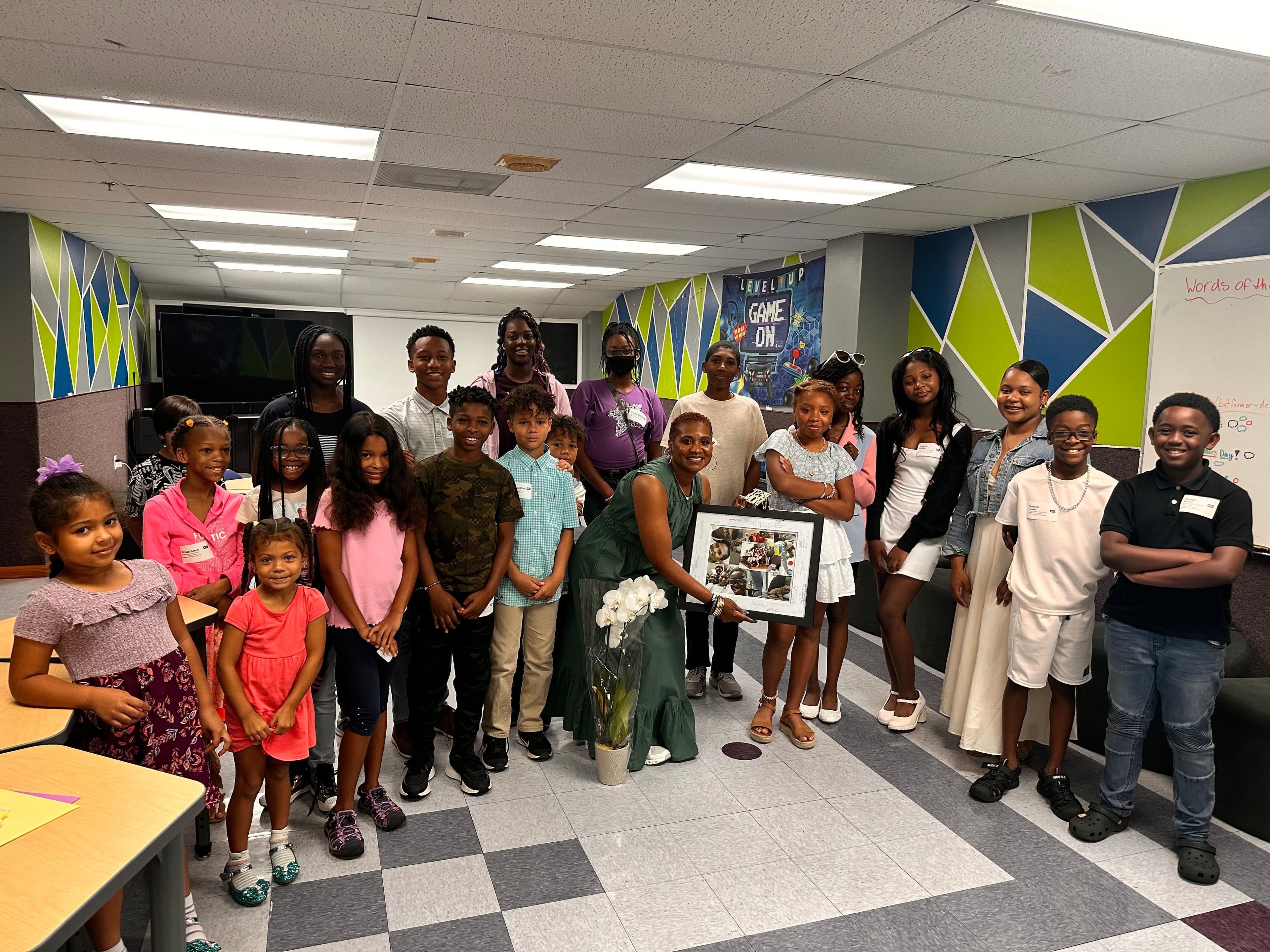 Youth and children gathered in a classroom group photo.