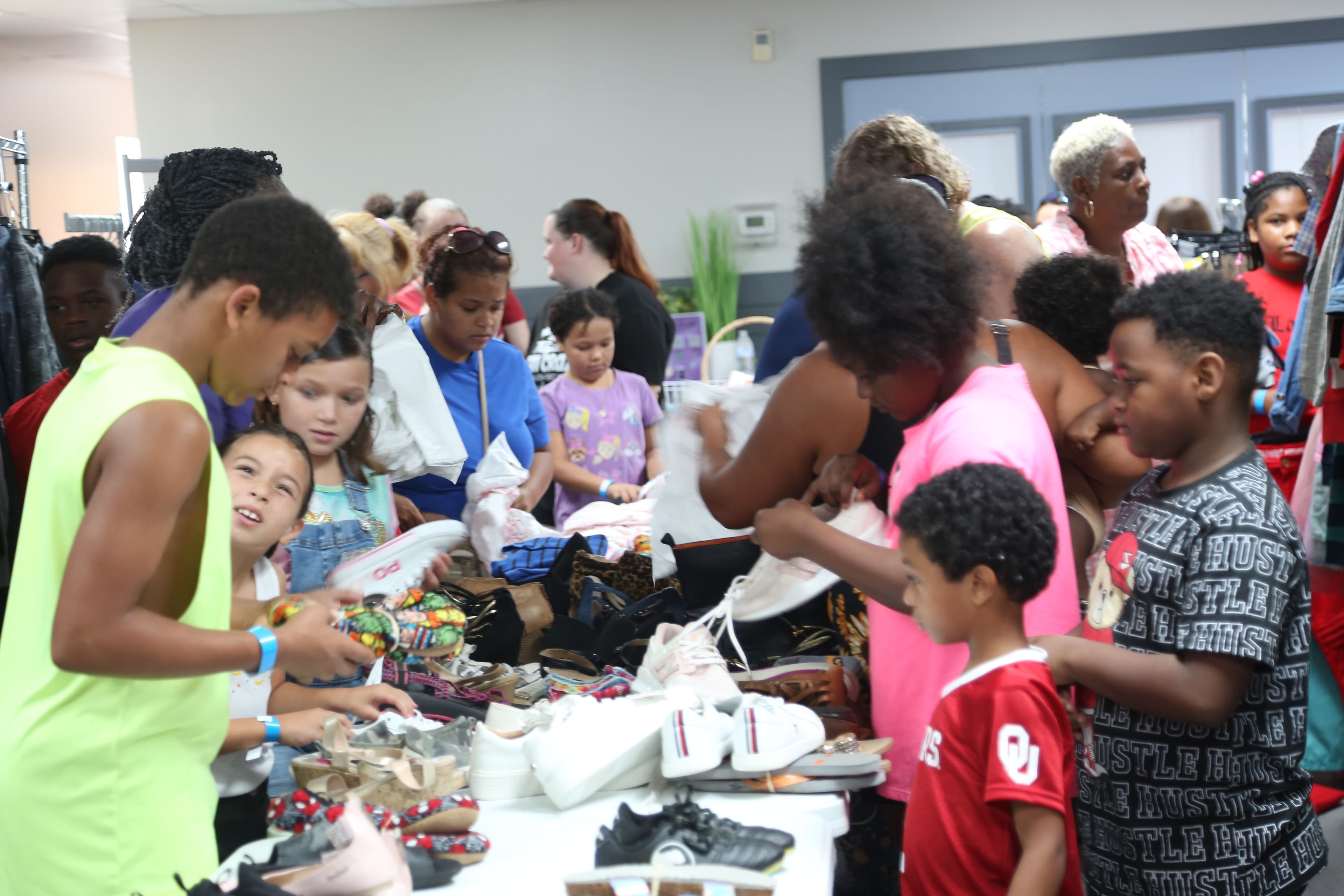 Youth outreach event with children selecting clothing and shoes.